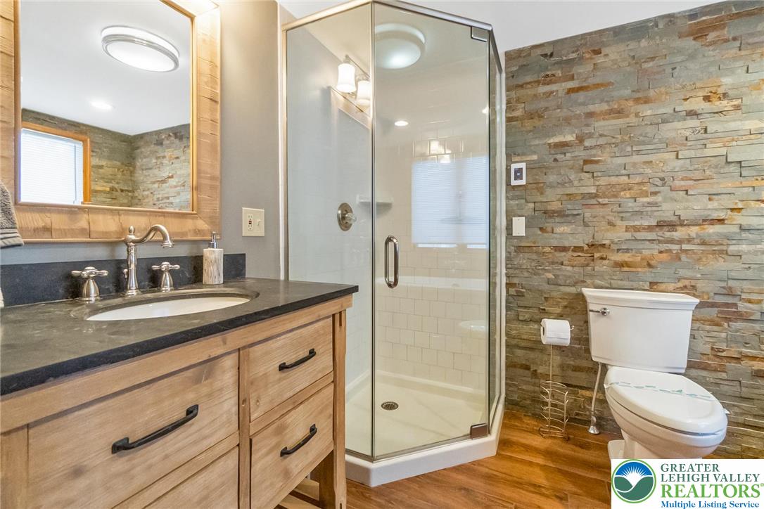 143 Moseywood Road Lake Harmony, PA 18624 - Photo 21 of 48 a bathroom with a granite countertop sink a toilet a mirror and shower