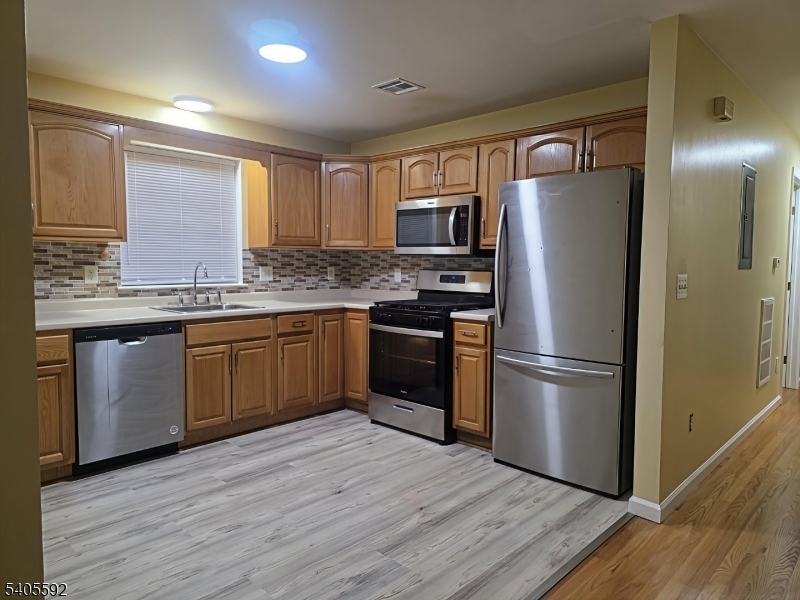 94 Palm Street, Unit 1 Newark, NJ 07106 - Photo 15 of 24 a kitchen with stainless steel appliances granite countertop a refrigerator a sink dishwasher a stove with wooden floor