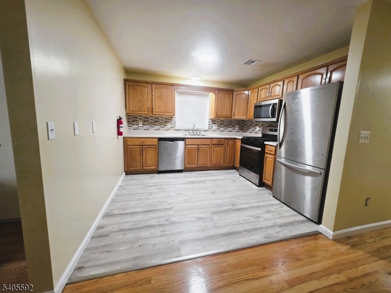 94 Palm Street, Unit 1 Newark, NJ 07106 - Photo 16 of 24 a kitchen with stainless steel appliances granite countertop a refrigerator and a stove top oven