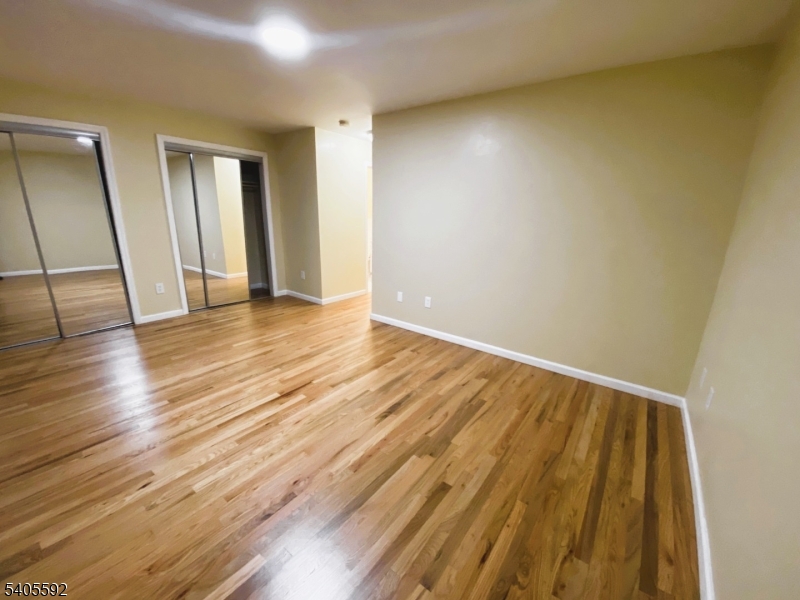94 Palm Street, Unit 1 Newark, NJ 07106 - Photo 22 of 24 a view of an empty room with wooden floor and a window
