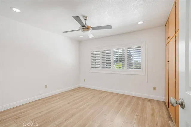 an empty room with a window and ceiling fan