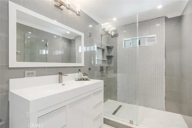 a bathroom with a sink a toilet a mirror and shower