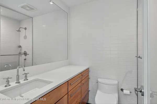 a bathroom with a sink toilet vanity and shower