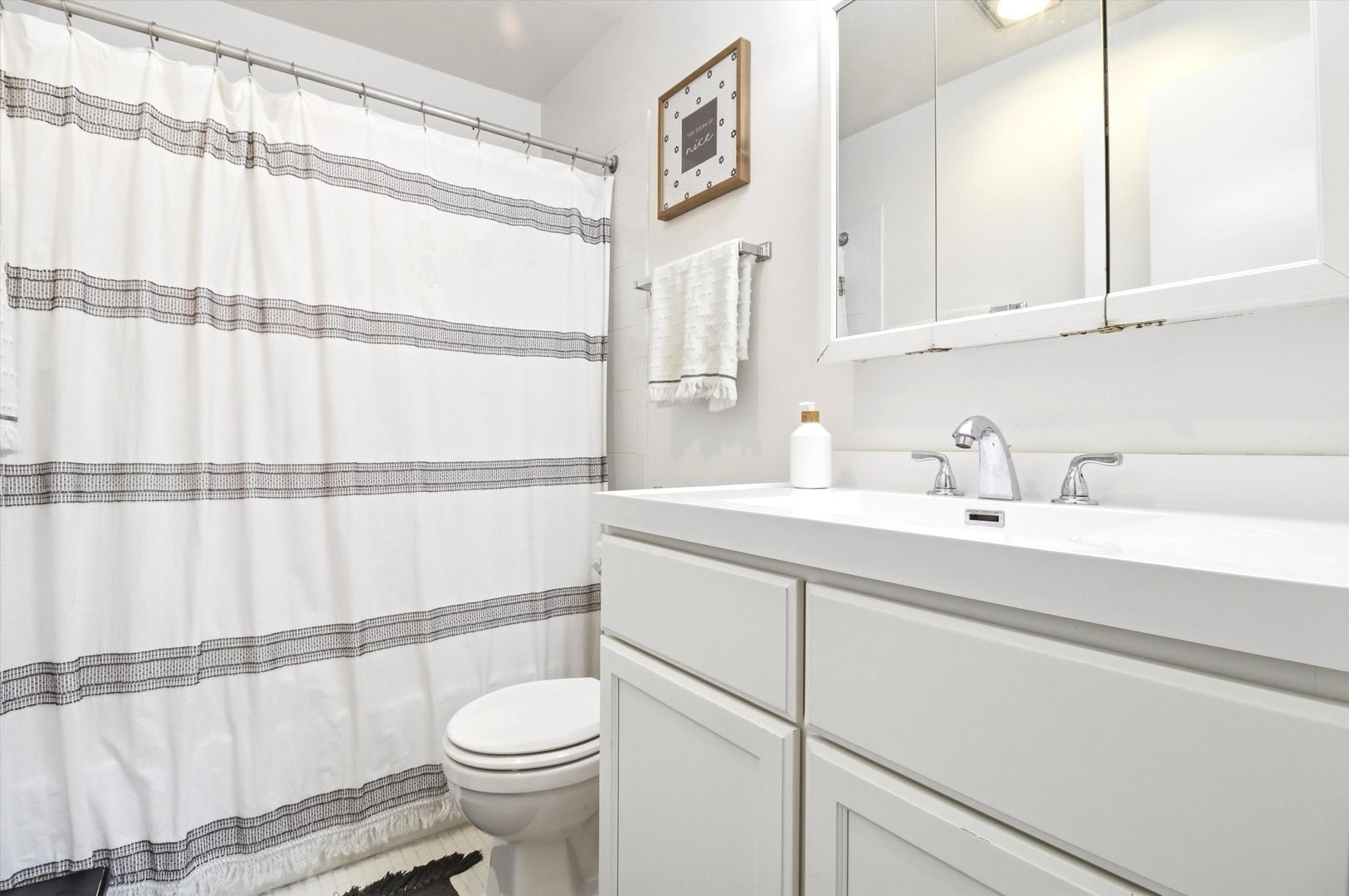 8640 Waukegan Road, Unit 123 Morton Grove, IL 60053 - Photo 12 of 30 a bathroom with a sink a toilet and shower