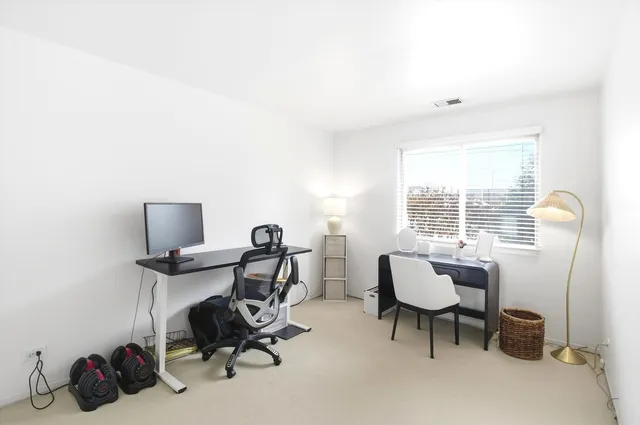 a view of a workspace with furniture and a window