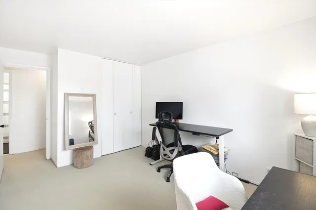 a view of a workspace with furniture and a window