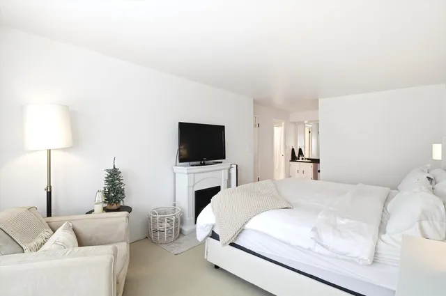 a spacious bedroom with a bed and a flat screen tv