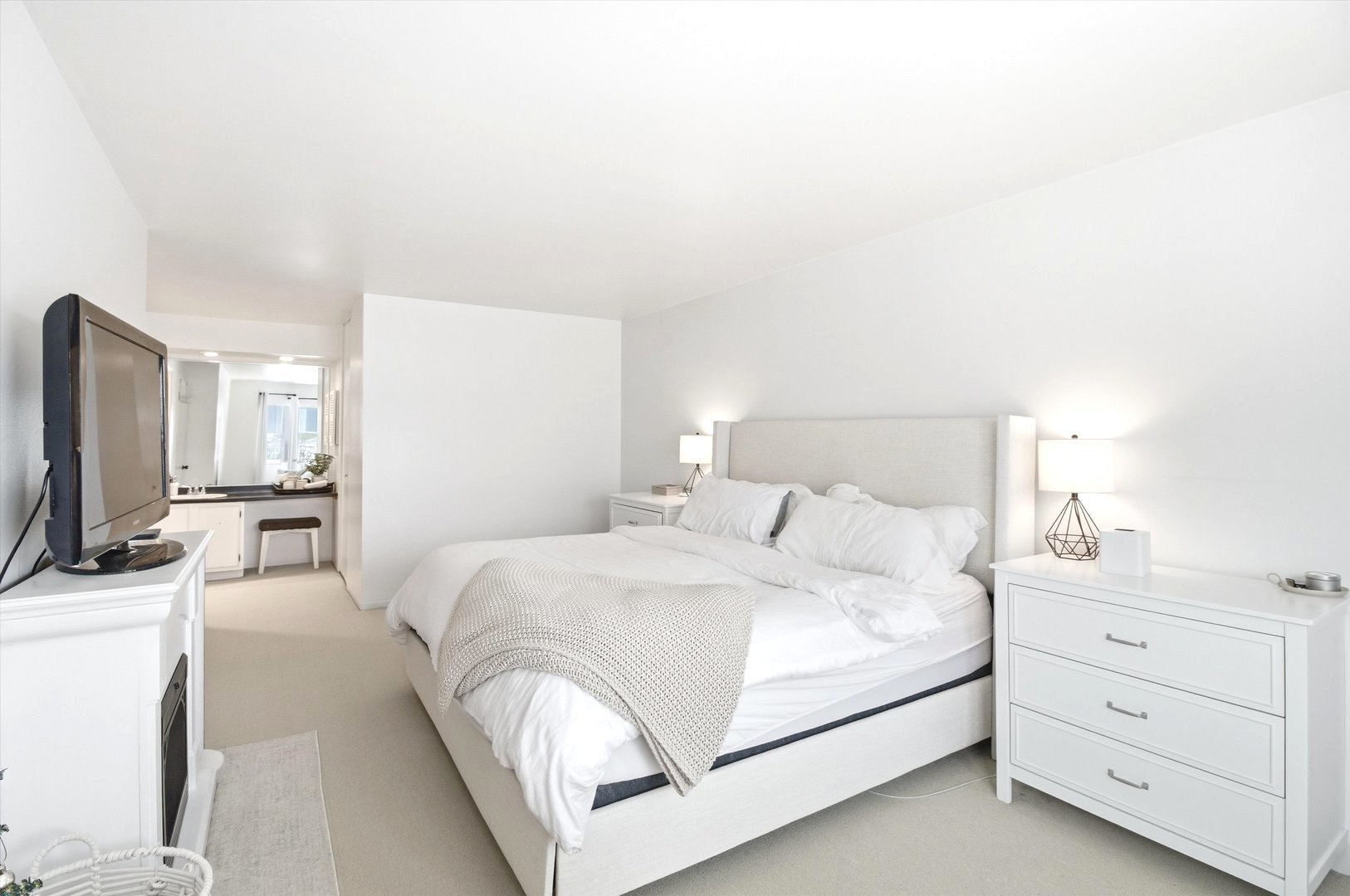 8640 Waukegan Road, Unit 123 Morton Grove, IL 60053 - Photo 19 of 30 a bedroom with a bed a couch and a flat tv screen on the dresser