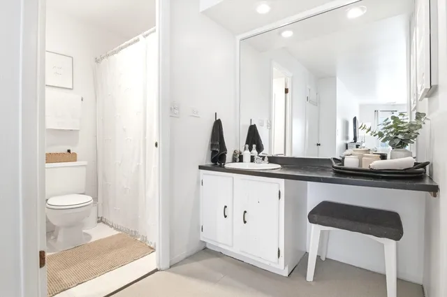 a bathroom with a toilet a sink and a mirror