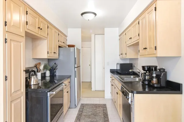 a kitchen with stainless steel appliances granite countertop a stove a refrigerator and a cabinets