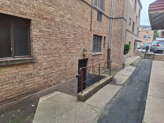 a view of a brick house with a bench in front of building