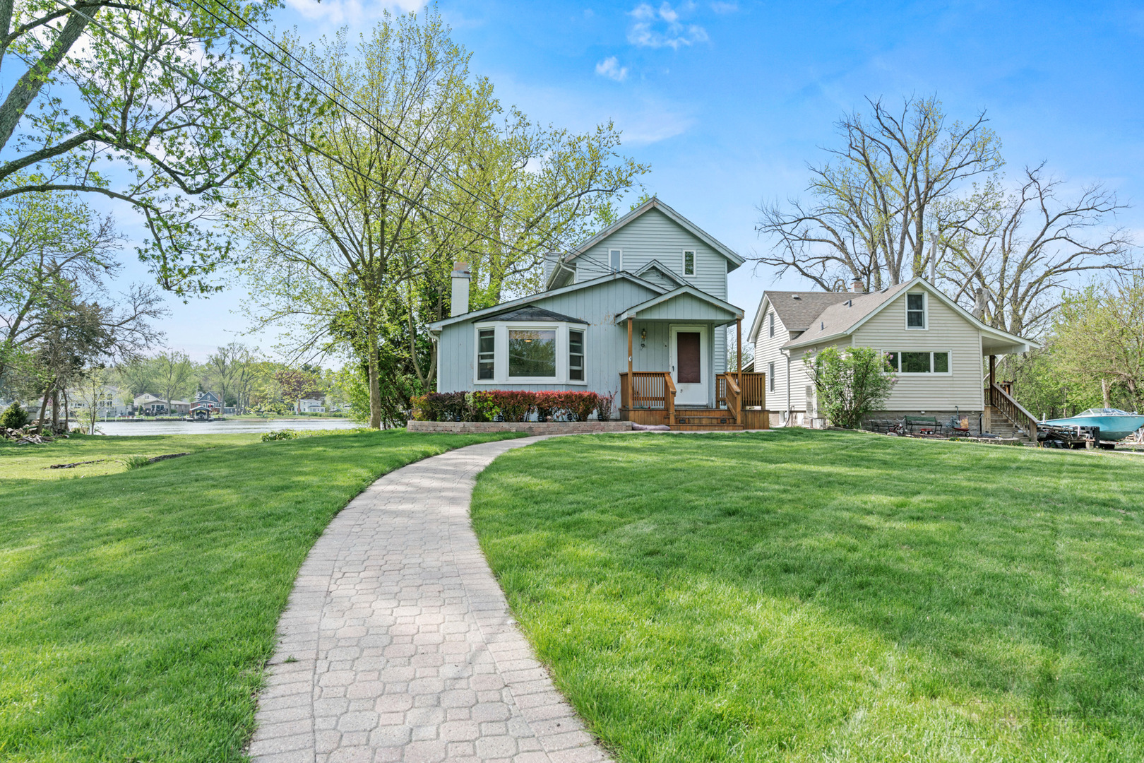 1307 Tower Lane Cary, IL 60013 - Photo 23 of 26 a front view of a house with a garden and trees