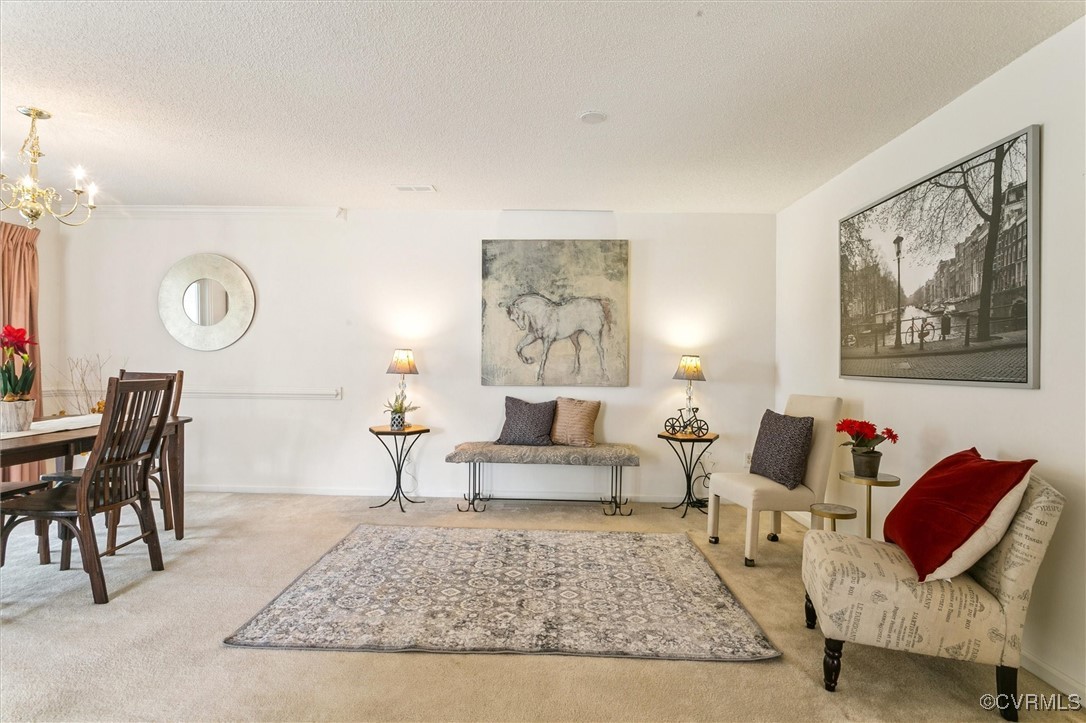 262 Claiborne Drive Williamsburg, VA 23185 - Photo 10 of 49 Carpeted living area with a chandelier and a textu