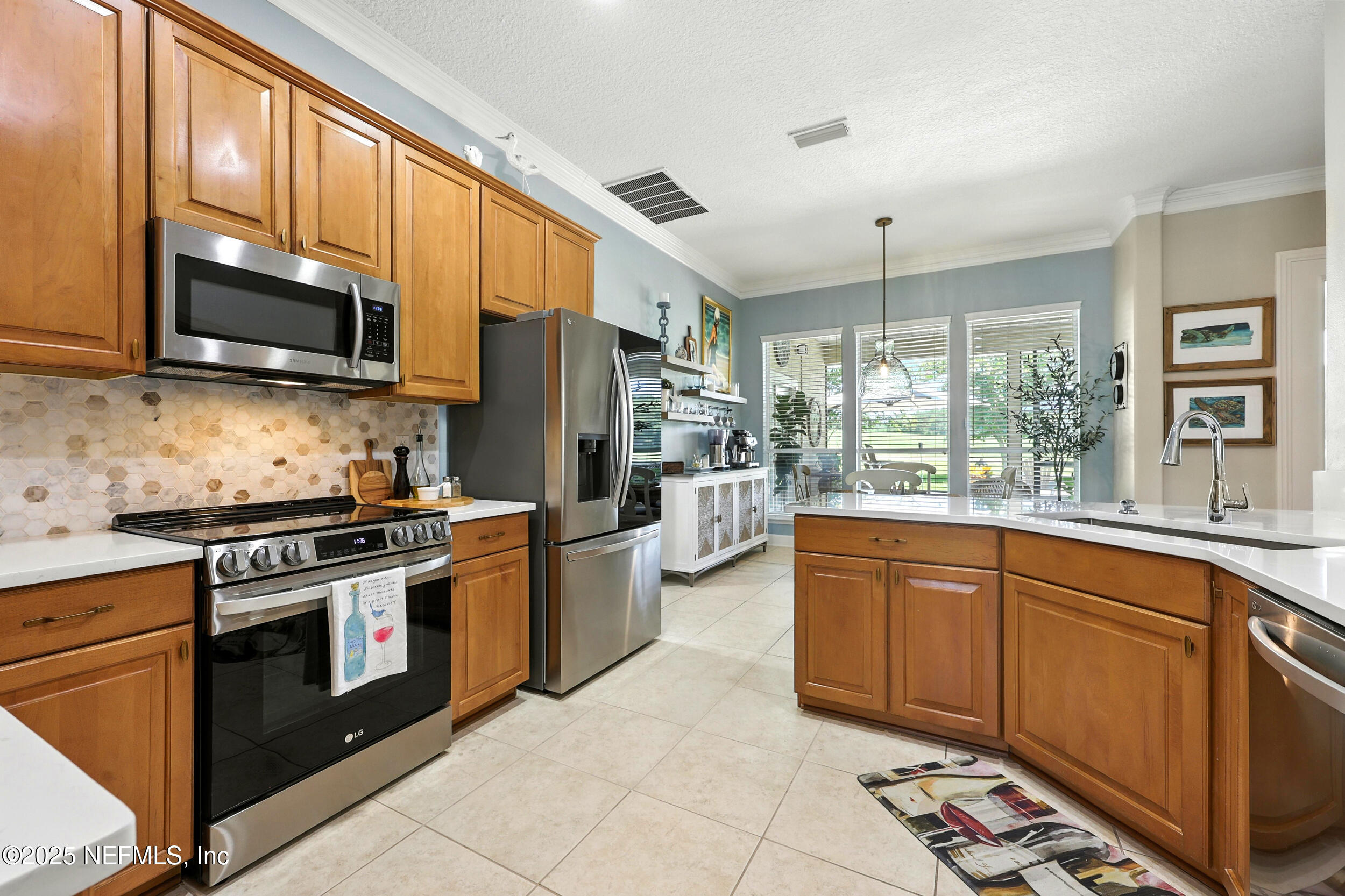 1185 Garrison Drive St. Augustine, FL 32092 - Photo 15 of 70 a kitchen with stainless steel appliances granite countertop a stove sink microwave and refrigerator