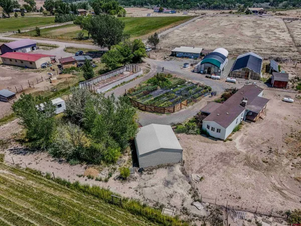 an aerial view of a house with a garden and lake view