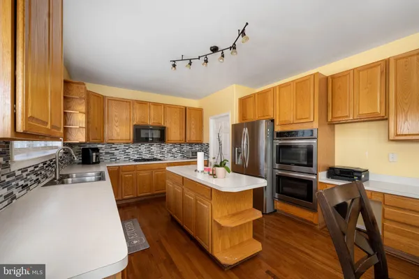 a kitchen with a sink a counter top space and stainless steel appliances