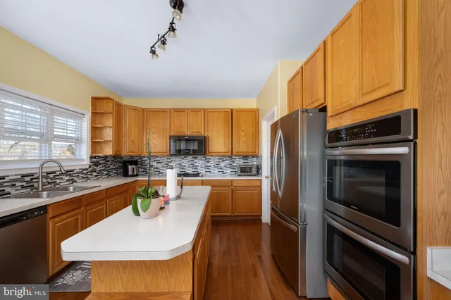 a bathroom with a granite countertop sink a mirror and shower