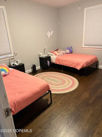 a bed room with two bed and a chair