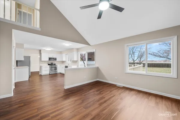 a view of a living room and kitchen with furniture wooden floor and window