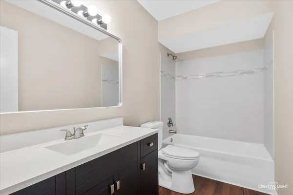 a bathroom with a toilet a sink a mirror and a bathtub