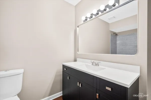 a bathroom with a sink vanity and a toilet