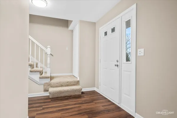 a view of a hallway with wooden floor and staircase
