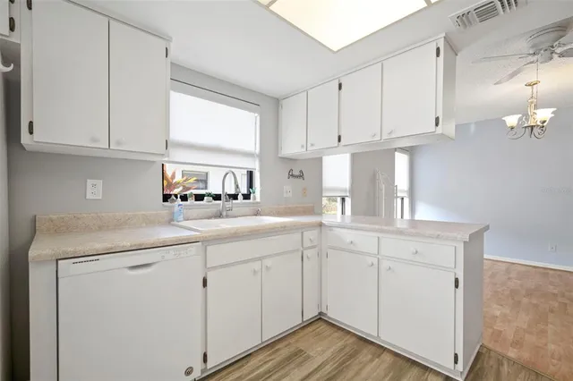 a kitchen with white cabinets and sink