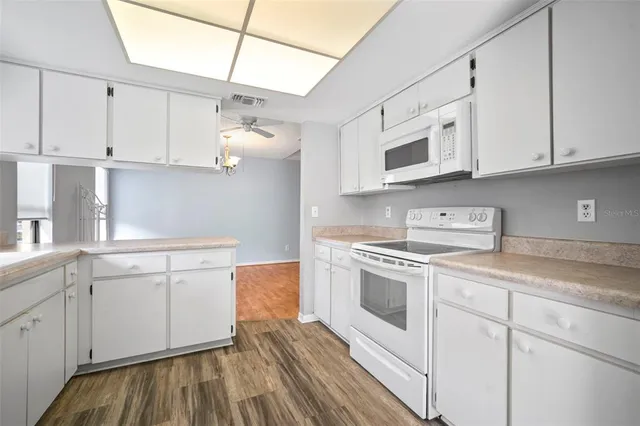 a kitchen with white cabinets and white appliances