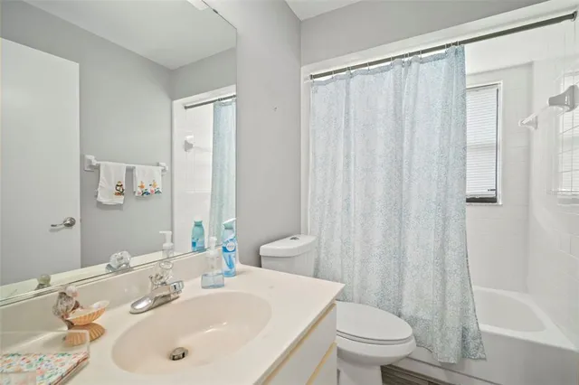 a bathroom with a sink a toilet and shower curtain