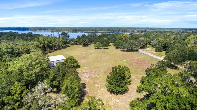 a view of a swimming pool with lake and houses in the back