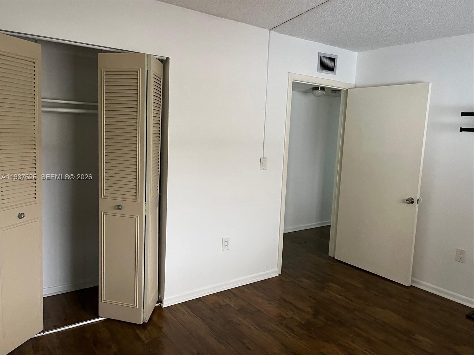 8420 Southwest 133rd Avenue Road, Unit 308 Miami, FL 33183 - Photo 11 of 16 a view of an empty room with wooden floor and closet area