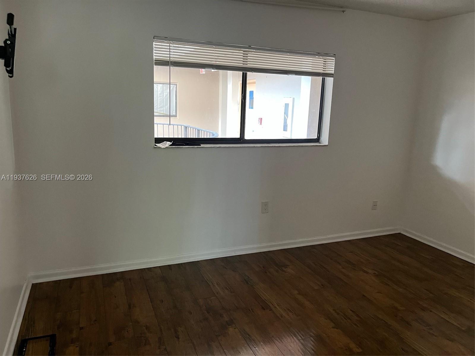 8420 Southwest 133rd Avenue Road, Unit 308 Miami, FL 33183 - Photo 12 of 16 an empty room with wooden floor and windows
