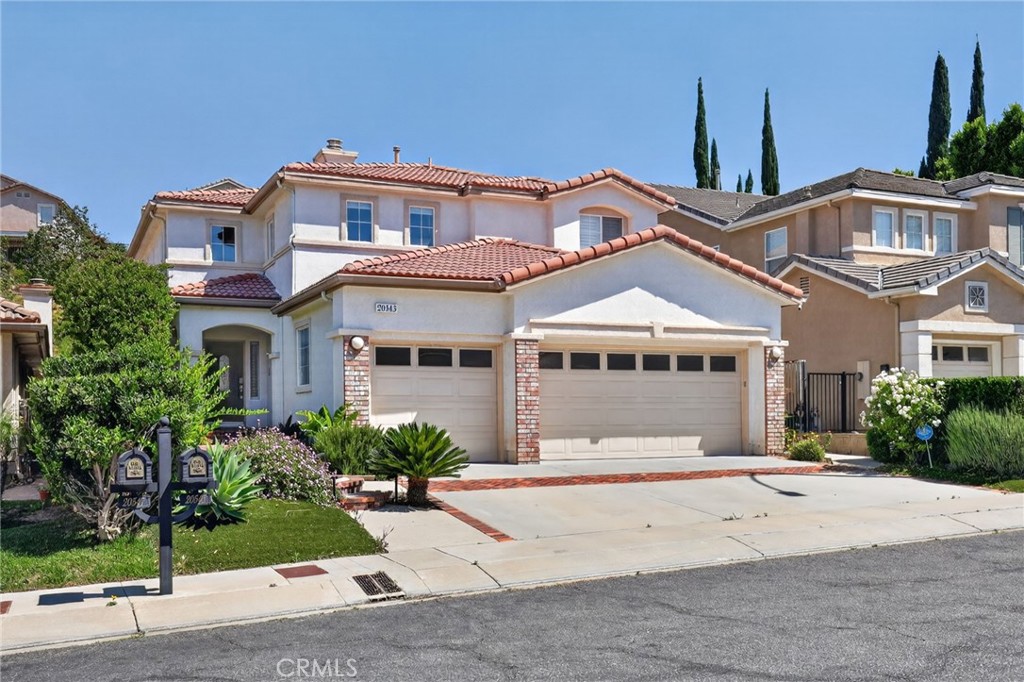 20543 Pesaro Porter Ranch Porter Ranch, CA 91326 - Photo 3 of 67 a front view of a house with a garden