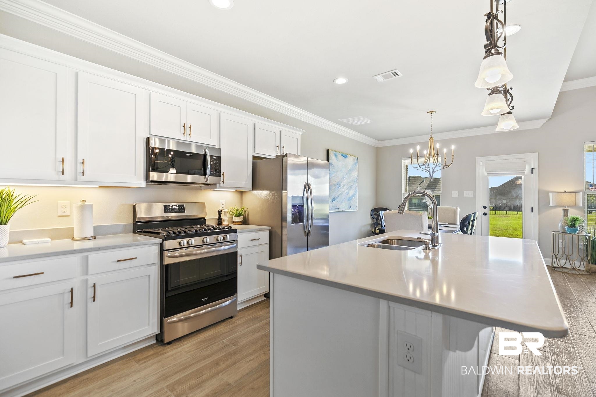 10140 Chipper Lane Foley, AL 36535 - Photo 18 of 72 Kitchen with stainless steel appliances, light hardwood / wood-style floors, sink, a kitchen island with sink, and white cabinets