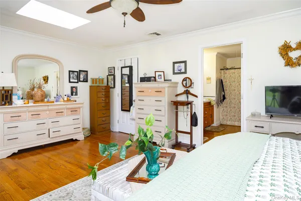 a bedroom with a bed and a flat tv screen on dresser