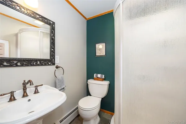 a bathroom with a toilet sink and mirror
