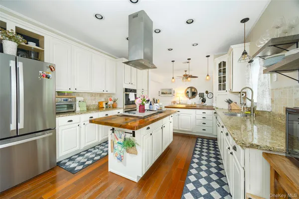 a kitchen with stainless steel appliances granite countertop a sink a stove and a refrigerator