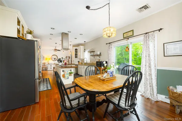 a dining room with furniture a chandelier and wooden floor