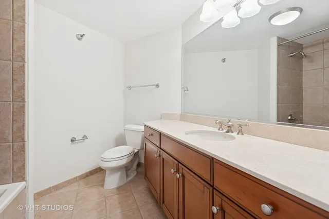 a bathroom with a granite countertop sink a toilet and a mirror
