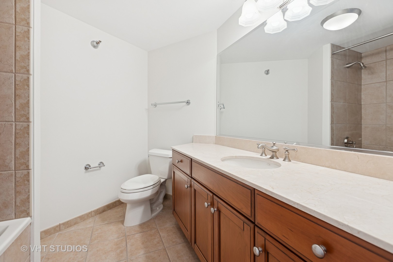 25 East Superior Street, Unit 2405 Chicago, IL 60611 - Photo 16 of 26 a bathroom with a granite countertop sink a toilet and a mirror