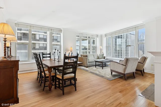 a dining room with furniture floor to ceiling windows and wooden floor