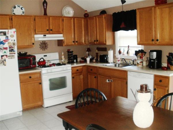 73 Musquash Road Hudson, NH 03051 - Photo 3 of 14 a kitchen with a sink a stove and cabinets