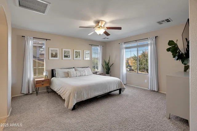 a spacious bedroom with a bed and a chandelier