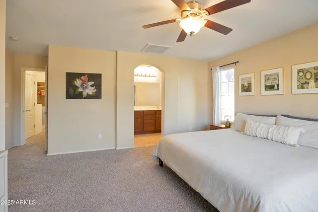 a bedroom with a large bed and a chandelier