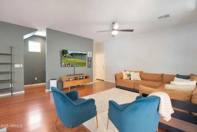 a living room with furniture and a wooden floor