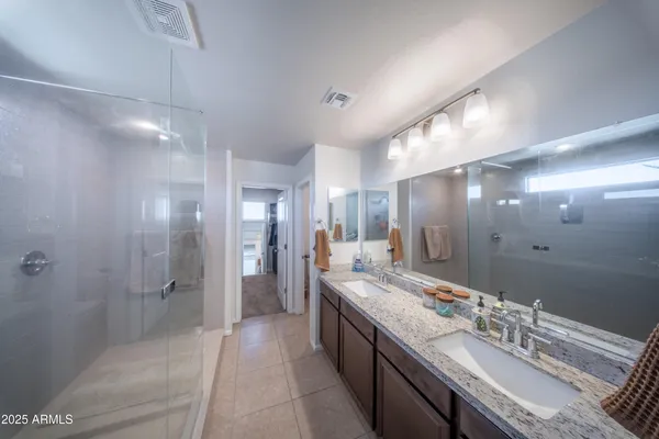 a bathroom with a double vanity sink mirror and shower