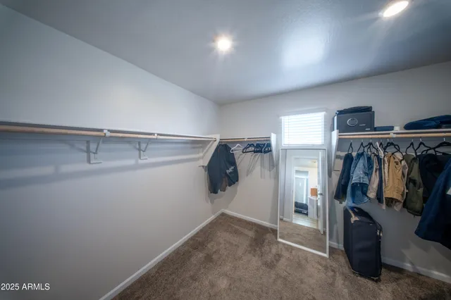 a view of walk in closet with clothes and shoes