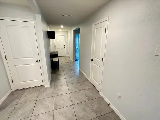 a view of a hallway to closet and microwave