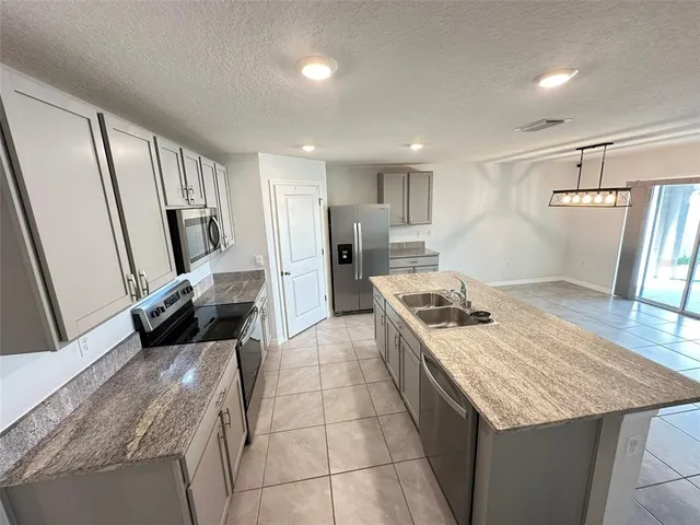 a kitchen with a stove a sink and a refrigerator