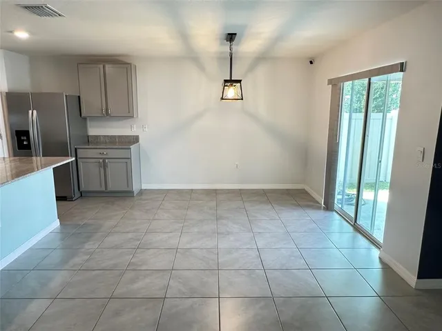 a kitchen with a stove a refrigerator and cabinets